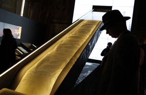 A visitor looks at an ancient scroll titled "Trial of the Templars of France" during the exhibition "Lux in Arcana, the Vatican Secret Archives reveals itself" at the Capitoline Museums in Rome