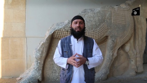 Un miliziano dell'ISIS, davanti a un antico bassorilievo 