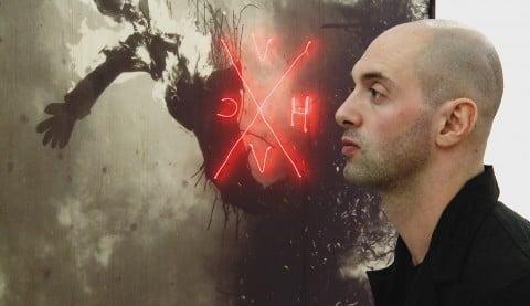 Nico Vascellari davanti a una sua opera