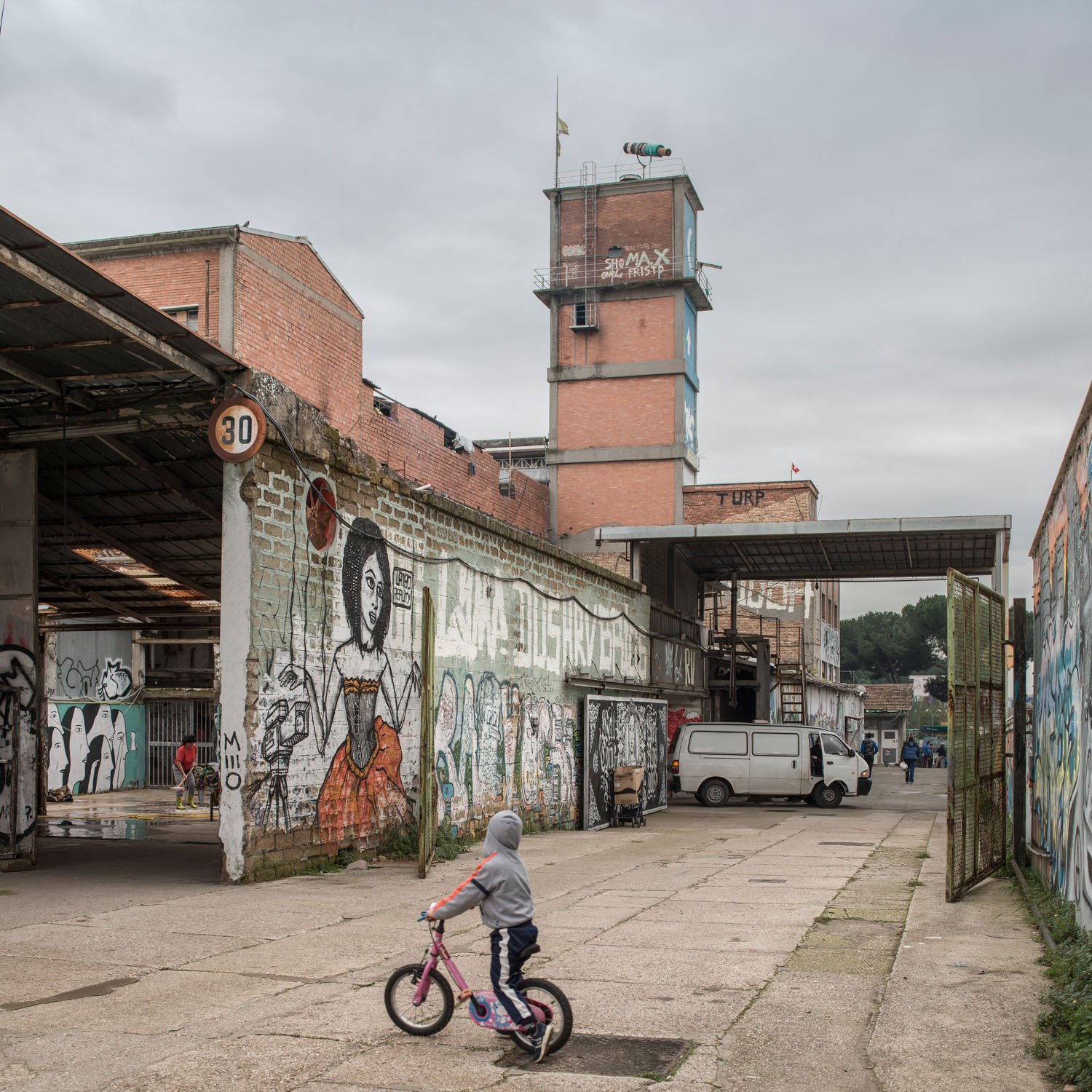 MAAM - Cortile esterno. Un bambino sulla sua bici. Sullo sfondo la torre di Metropoliz con in cima il telescopio di Gian Maria Tosatti - photo Giuliano Ottaviani