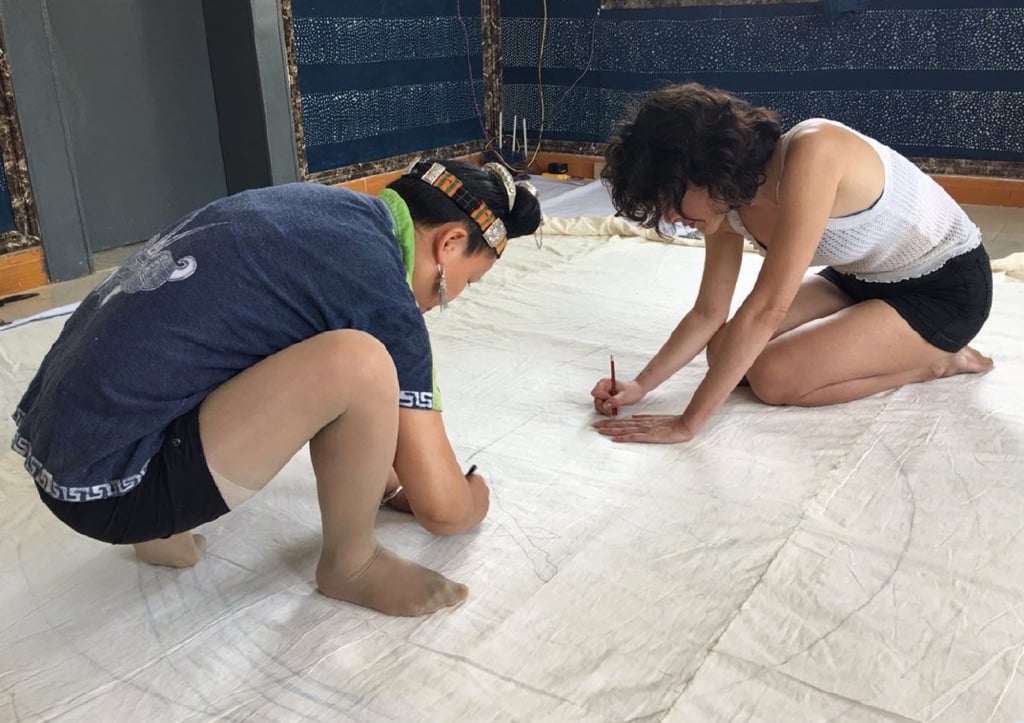 Land Art Mongolia Biennale – Lisa Batacchi – Lavorando insieme con le donne Miao disegnando a matita su tessuto rintracciando le linee dal modello di carta sottostante - photo credits Lisa Batacchi