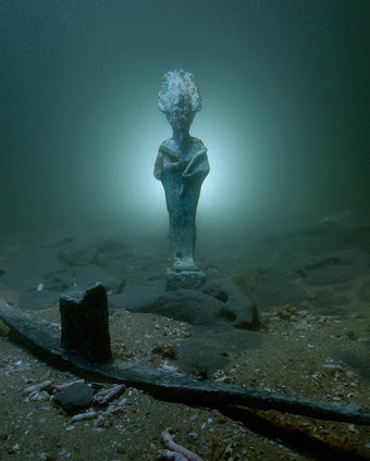 Bronze statuette of Osiris and lead votive barque on the seabed in Thonis-Heracleion, Bay of Aboukir, Egypt (SCA 1081, 1039). Image Christoph Gerigk © Franck Goddio, Hilti Foundation 