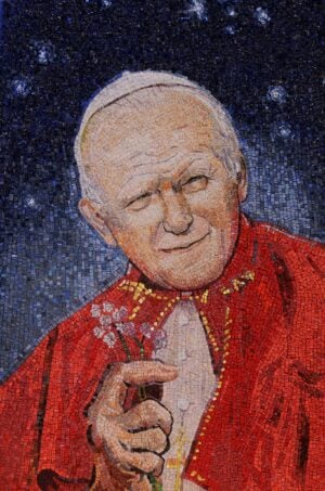 Ma che vi ha fatto di male il povero Wojtyla? Dopo il “capoccione” di Rainaldi, arriva il mosaico “manone” di Luca Vernizzi. Docente a Brera…