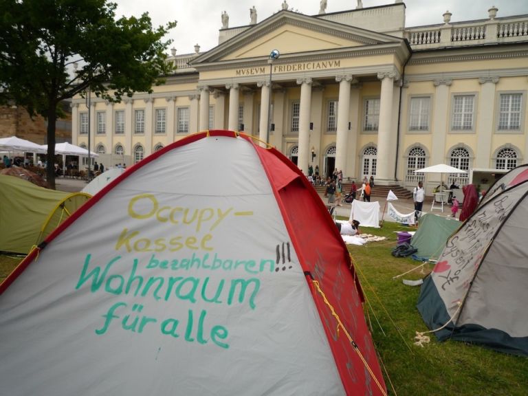 Friedrichsplatz Kassel – »doccupy« movement 1 La “d” come documenta, ma anche come d-Occupy. Il movimento pervade la rassegna di Kassel, Carolyn Christov-Bakargiev lo accoglie. E un po’ lo irreggimenta…