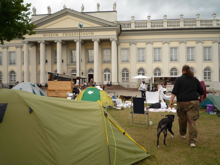 Friedrichsplatz Kassel – »doccupy« movement 2 La “d” come documenta, ma anche come d-Occupy. Il movimento pervade la rassegna di Kassel, Carolyn Christov-Bakargiev lo accoglie. E un po’ lo irreggimenta…