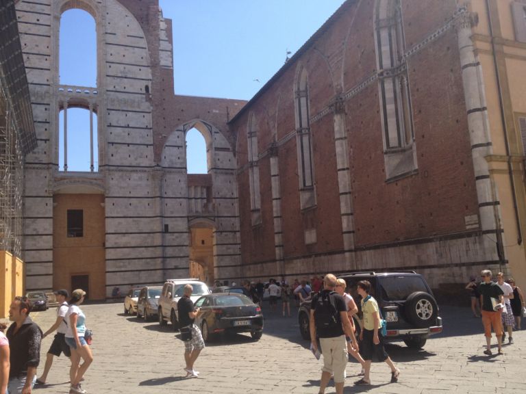 Lesterno del Duomo invaso dalle auto Siena, il Duomo. Il pavimento più bello del mondo e il bar-da-museo più squallido del mondo. Per le migliaia di visitatori della scopertura straordinaria solo macchinette automatiche
