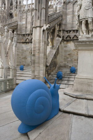Lumache blu in processione sulla terrazza del Duomo di Milano. Inquinamento e global warming non c’entrano: trattasi di raccolta fondi firmata Cracking Art