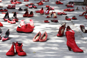 Guardare il mondo “Con i tuoi occhi”. Quelli delle donne che hanno subito violenza. Una performance a Milano: centinaia di scarpe rosse contro femminicidi e abusi