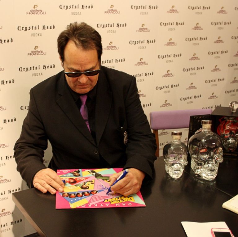 Dan Aykroyd firma autografi foto Michela Deponti Dan Aykroyd distillatore a Milano: bottiglia d’artista e design italiano per Crystal Head, vodka con cui l’ex Blues Brother ha conquistato il mondo. Partendo dal suo Canada per spopolare persino a Mosca