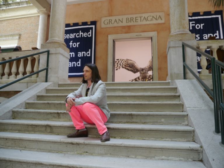 Geremy Deller posa davanti al Padiglione Gran Bretagna Biennale Updates: musica maestro! Dai crooner animati di Mathias Poledna ai dj set di Gilat Ratman, passando naturalmente per i pianisti di Anri Sala. In Laguna è insistito il rapporto tra arte e musica