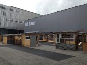 Basel Updates: collezionisti milionari chiusi per un drink in baracche di legno. Tante foto dal “Favela Café” di Tadahi Kawamata a Messeplatz