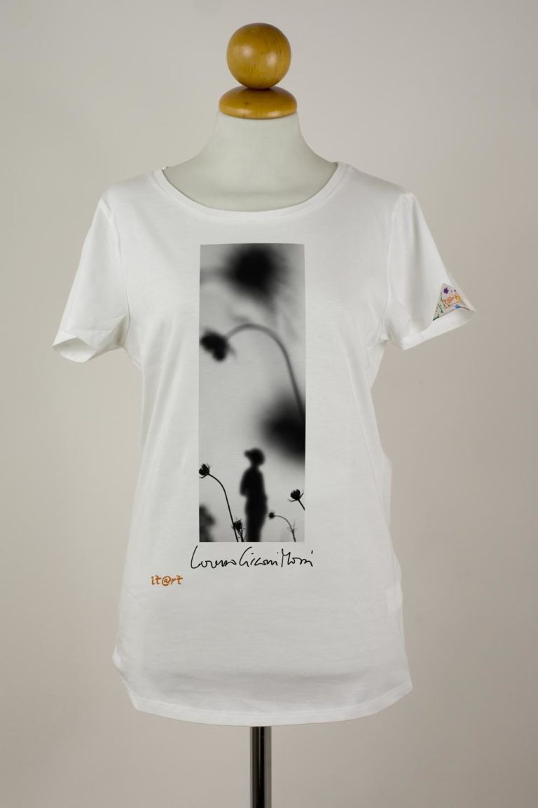 donna davanti figura con fiori Opere d'arte in forma di t-shirt. Connubio antico e sempre accattivante. Ecco quelle del progetto It@rt: firme di maestri italiani, da indossare e collezionare. Multipli, con firma d'autore