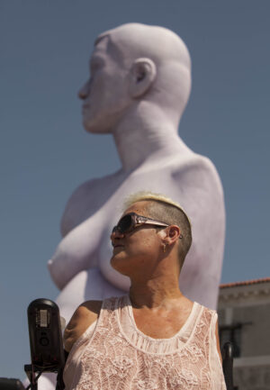 Alison & Alison. L’artista disabile che posò per Marc Quinn, in visita a Venezia in una giornata d’agosto. Le foto insieme alla riproduzione della grande statua dedicatele nel 2005