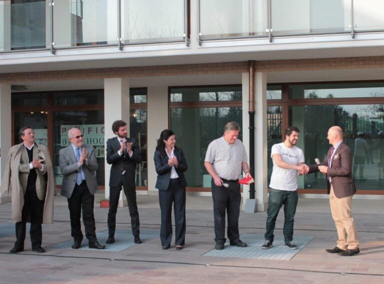 Andrea Mastrovito stringe la mano a Edoardo Perazzi nipote di Oriana Fallaci courtesy GAMeC Galleria dArte Moderna e Contemporanea di Bergamo Parole di cemento. A Bergamo Andrea Mastrovito inaugura l’opera pubblica con cui si è aggiudicato il concorso Qui l’arte è di casa: ecco le immagini