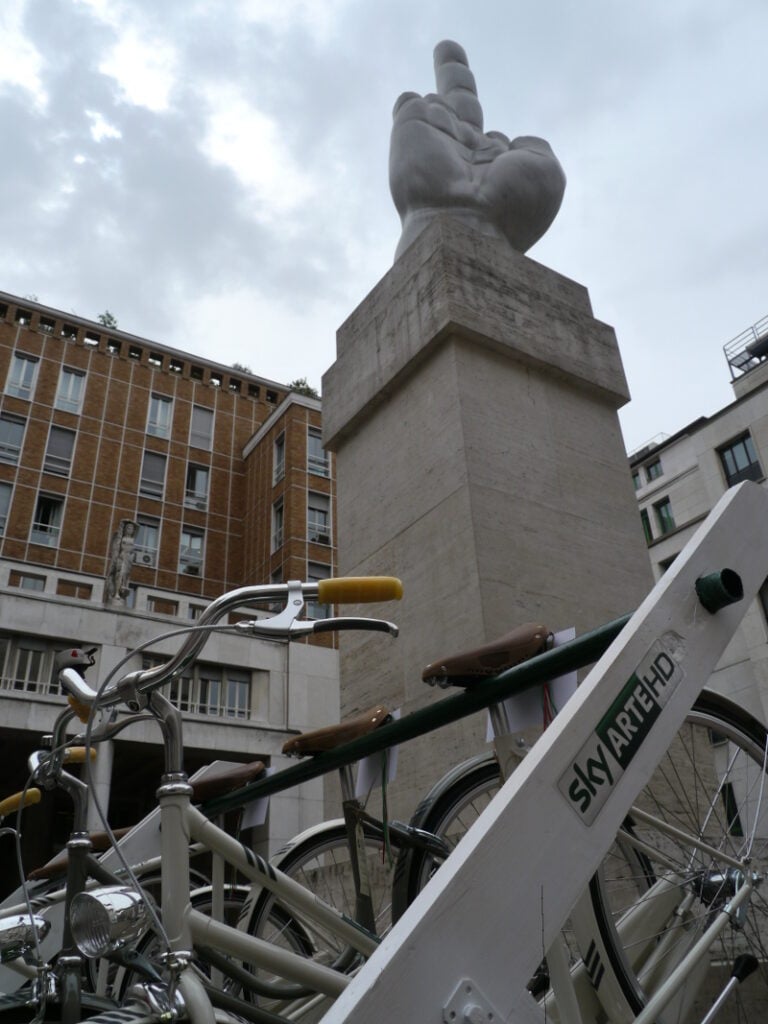 Salone Updates: Sky Arte HD porta il design in Piazza Affari. All’ombra del dito di Maurizio Cattelan la stazione per il bike-sharing gratuito offerto dal canale tv; in attesa dell’installazione video di Yuri Ancarani