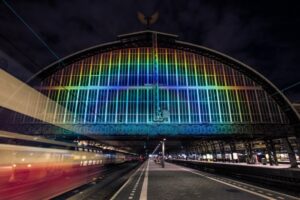 L’arcobaleno di Amsterdam. Rainbow Station illumina il tetto della vecchia stazione. Un incantesimo tecnologico e monumentale
