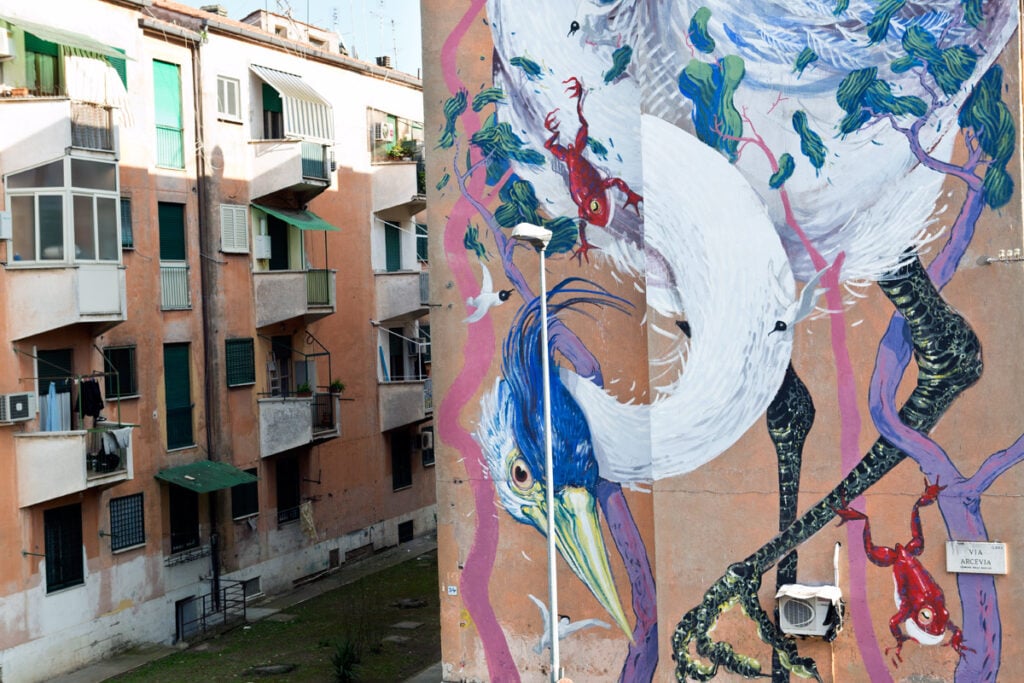 Rifatevi gli occhi. Lo street artist romano Hitnes ridipinge sei facciate del quartiere San Basilio. Vi mostriamo i primi quattro murales, targati SanBa