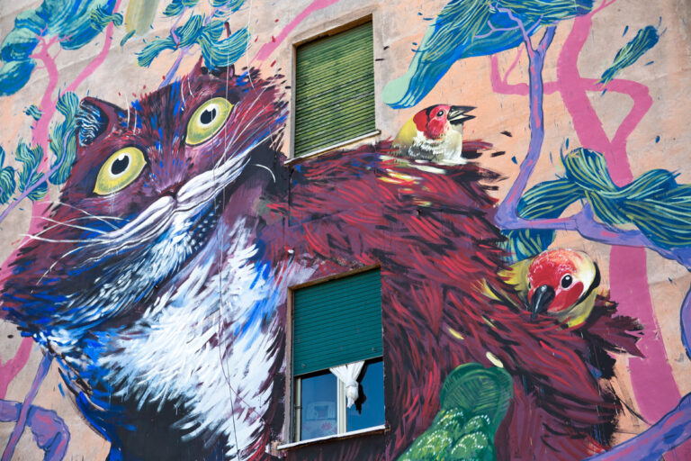 Hitnes per Sanba Roma 2015 Rifatevi gli occhi. Lo street artist romano Hitnes ridipinge sei facciate del quartiere San Basilio. Vi mostriamo i primi quattro murales, targati SanBa