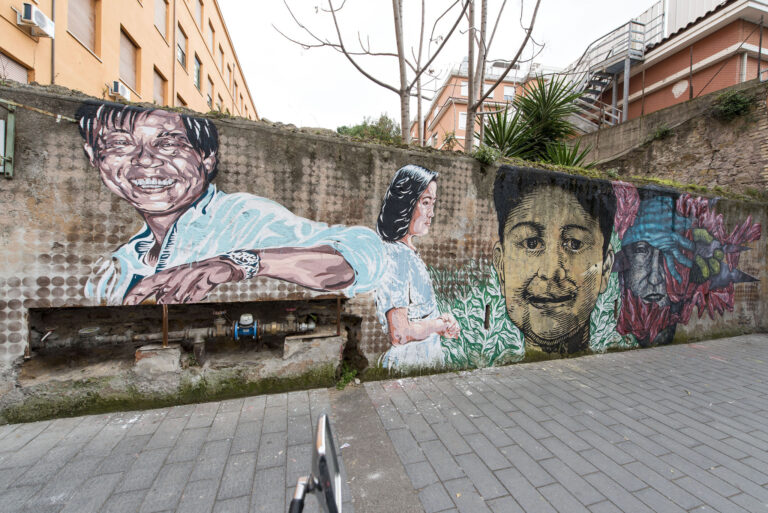 Diavù Lucamaleonte e Nic Alessandrini il muro nel quaretiere meticcio di Torpignattara foto Giorgio Benni L’anima sociale della street art romana e il cuore multietnico di Torpignattara. Finito il muro dei migranti. E parte il crowdfunding per il film