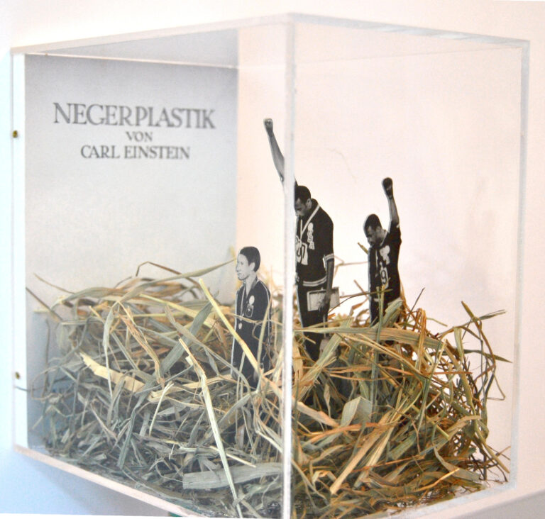 Alex Urso Negerplastik1 2014 paper figures straw plexiglass box 185x13x19 cm Italiani in trasferta. Artista Pasquale De Sensi, curatore Alex Urso: immagini della mostra all'Istituto di Cultura Italiana a Varsavia