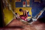 Steve McCurry, A farmer and his son play in a hammock at home, La Esperanza, Colombia, 2004