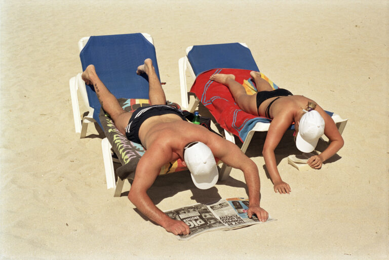 Martin Parr, Bagno di sole e lettura sulla spaggia, Magaluf, Mallorca, Spagna, 2003 - © Martin Parr/Magnum Photos