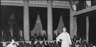 Sfilata Moda Circus - Modello sfila in passerella con maschere Veneziane. Venezia, Palazzo Grassi, settembre 1961 © Archivio Carlo Montanaro