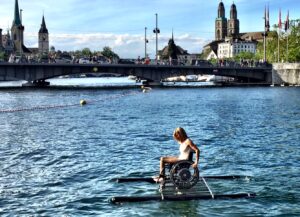 L’ultima performance di Maurizio Cattelan a Zurigo. Una campionessa paralimpica solca il lago con la sua sedia a rotelle