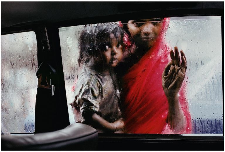 Steve McCurry, Una donna con la figlia guarda verso l’interno di un’auto. Mumbai, India, 1993 - Photographs Copyright © 2016, Steve McCurry