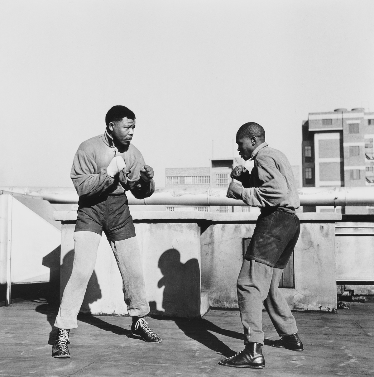 Bob Gosani, Treason Trial. End of Round One Mandela boxing on the roof top of a building in Johannesburg, 1957, 2010, © l’artista
