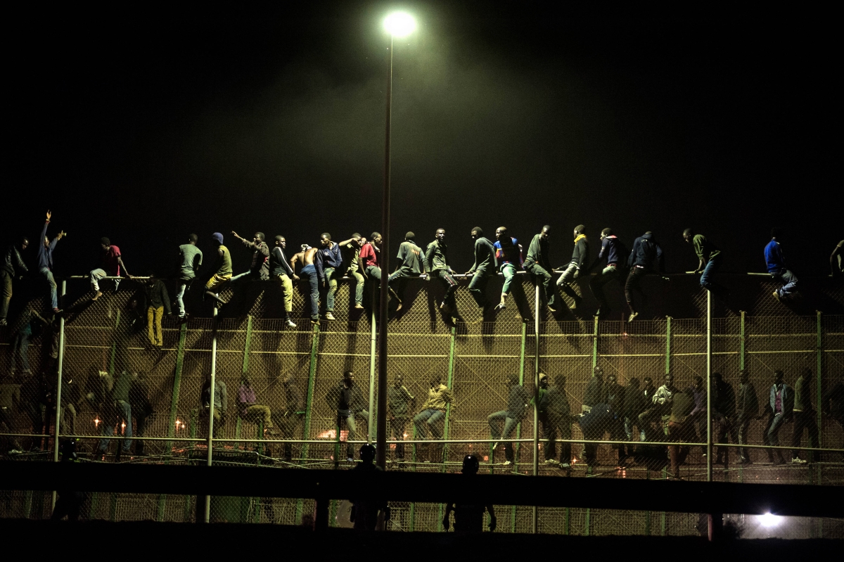 Melilla, Spagna, agosto 2014. Immigrati subsahariani cercano di scavalcare la rete di confine tra Spagna e Marocco © Giulio Piscitelli -Contrasto