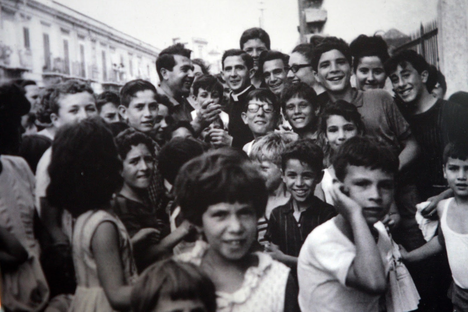 Un giovane Don Pino Puglisi con i ragazzini del quartiere Brancaccio, a Palermo