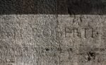 La firma dell’artista francese Hubert Robert iscritta su un pilastro dell’ambulacro al II ordine dell’anfiteatro, 1762. Courtesy Archivio fotografico SS COL. Photo Francesca Montella