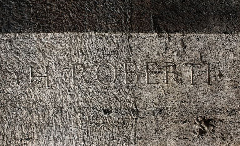 La firma dell’artista francese Hubert Robert iscritta su un pilastro dell’ambulacro al II ordine dell’anfiteatro, 1762. Courtesy Archivio fotografico SS COL. Photo Francesca Montella