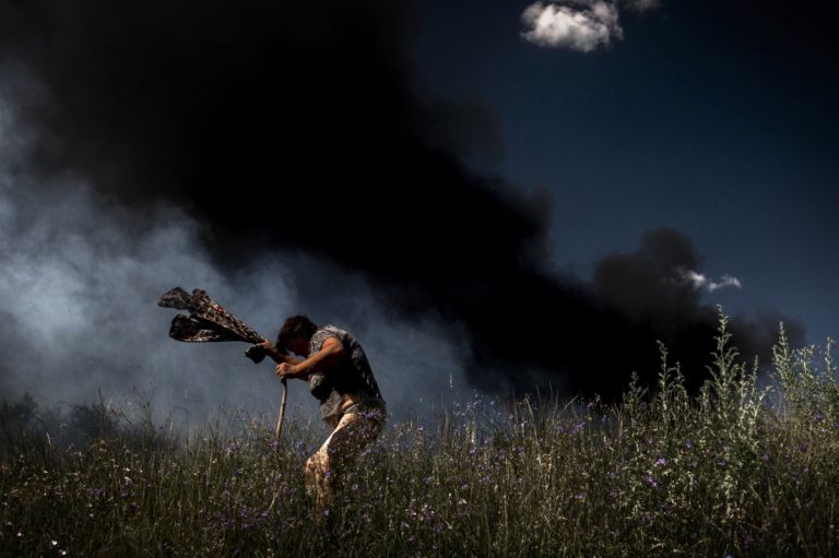 Valery Melnikov, Rossiya Segodnya, A woman escapes from a fire during an artillery attack in Krasnodon highway