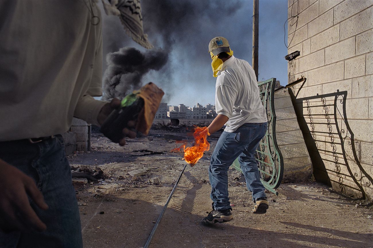 In una delle prime manifestazioni della seconda Intifada palestinese, i dimostranti lanciano pietre e molotov contro i soldati, che sparano munizioni vere e proiettili di gomma, a volte letali. Cisgiordania, Ramallah, 2000 © James Nachtwey/Contrasto