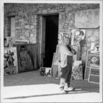 André Gomes, Pablo Picasso posa con le sue tele “Nudo seduto, Testa di profilo, Testa di donna, Busto di giovane” nell’atelier di Notre-Dame-de-Vie, Mougins, aprile 1965. Stampa non datata. Musée national Picasso-Paris