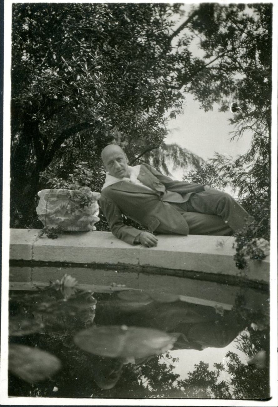 D'Annunzio semisdraiato a bordo fontana nei giardini del Vittoriale. Archivio Fondazione Vittoriale degli Italiani