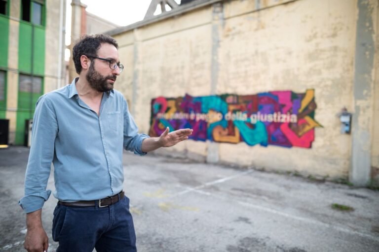 Il curatore Davide Ferri. Sullo sfondo il murale di Luca Bertolo nel cortile di EXATR, Forlì 2018. Photo Gianluca Camporesi