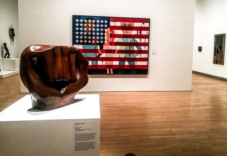 A sx, Elizabeth Catlett, Black Unity, 1968. A dx, Faith Ringgold, #18. The Flag Is Bleeding, 1967, dalla serie The American People. Installation view at Brooklyn Museum, New York 2018