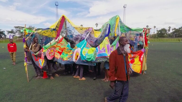 Carnival!Nairobi. Il carro Dragon Matatu realizzato a Mtindwa sfila allo Stadio di Nairobi in occasione dell'International Day of Street Children 2018. Still da video di Derek MF Di Fabio. Courtesy Cherimus