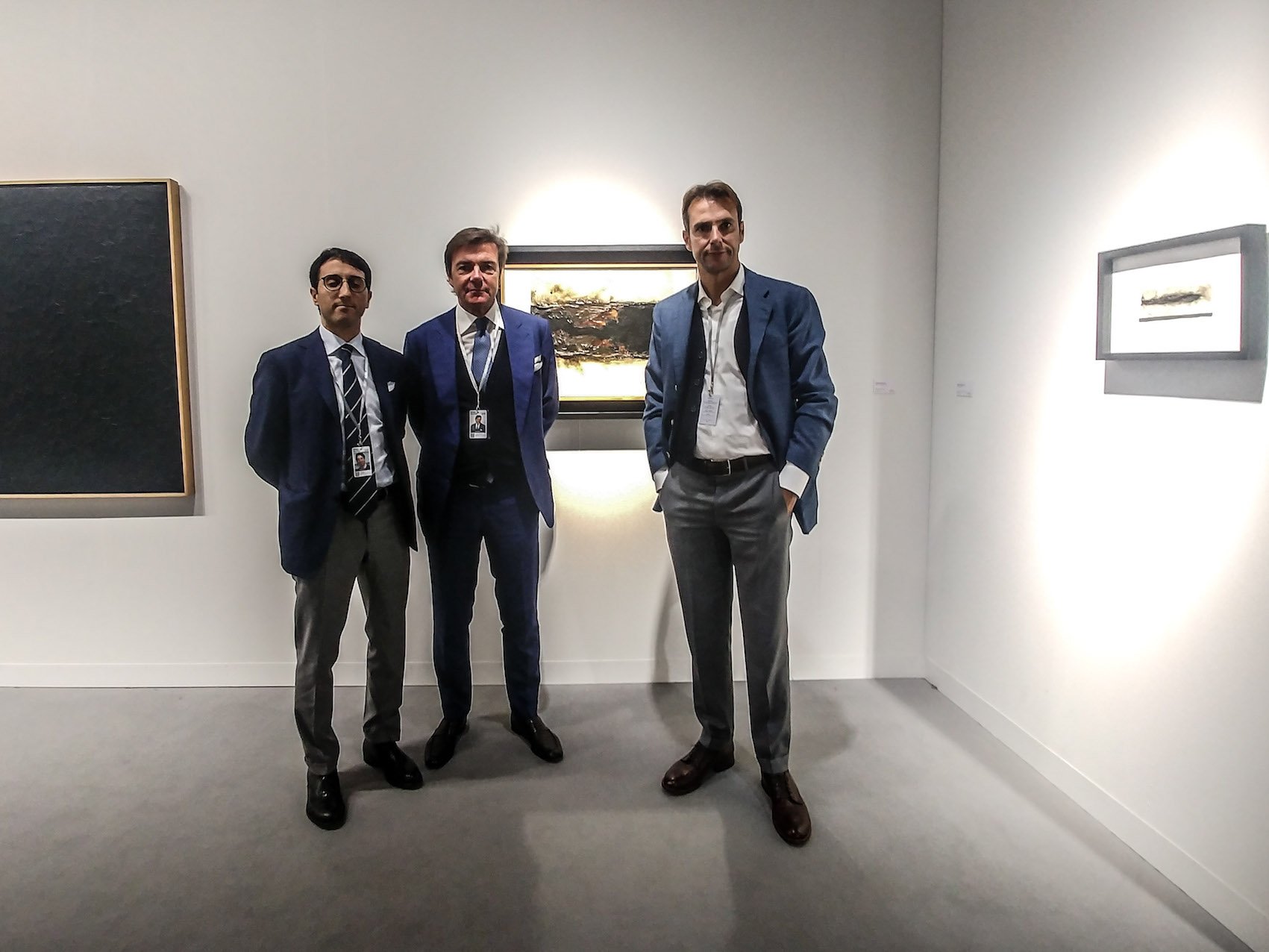 Da sinistra: Jose Graci, Davide e Luigi Mazzoleni con alle spalle Bianco Plastica B 2 di Alberto Burri