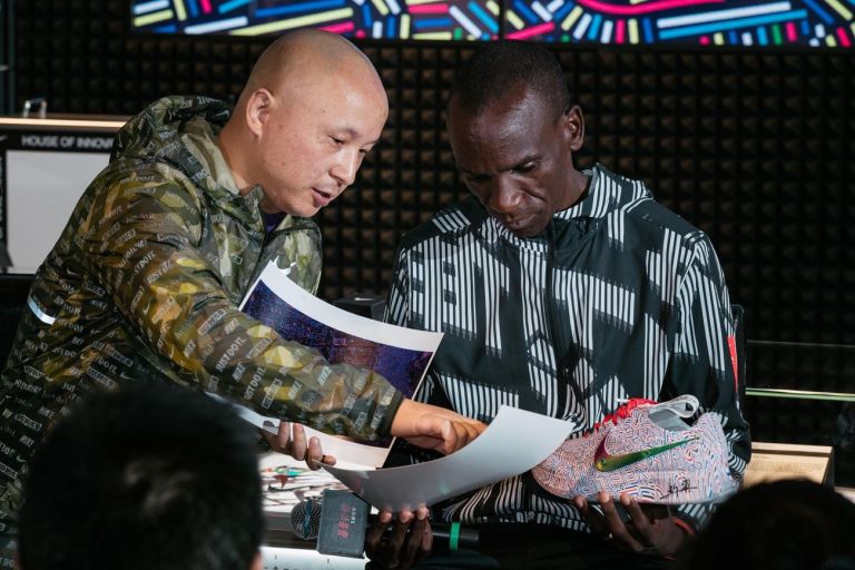 Lu Xinjian spiega il concept alla base delle quattro diverse tavole di pattern a Eliud Kipchoge