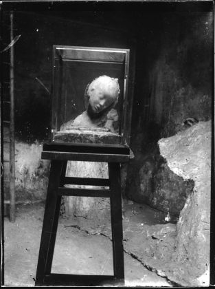L’Enfant Malade nell’atelier in Boulevard des Batignolles; sul fondo il gesso di Paris la nuit, con la base ancora integra. Stampa moderna a contatto da negativo originale su vetro, 17,8 x 11,5cm, 1898 circa