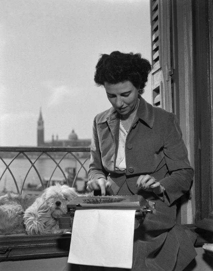 Peggy Guggenheim alla macchina da scrivere nella sua stanza all'Hotel Savoia & Jolanda, in Riva degli Schiavoni, Venezia, 1948. © Fondazione Solomon R. Guggenheim, foto Archivio CameraphotoEpoche, donazione Cassa di Risparmio di Venezia, 2005