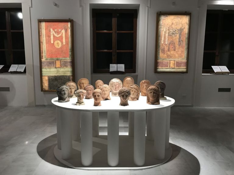 Quando le statue sognano. Exhibition view at Museo Salinas, Palermo 2019. Pareti dipinte con festoni e maschere dionisiache in stile pompeiano (I sec. a. C.) _ Ex voto di terracotta da Cales (IV - II sec a.C.)