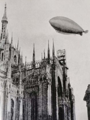 1910, Un dirigibile doppia le guglie del Duomo_ fotografia Archivio Publifoto Olympia_ Città_ N 7_ 1999 min