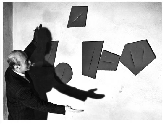Lucio Fontana with a work from the series I Quanta, 1959-1960. Courtesy of Fondazione Lucio Fontana