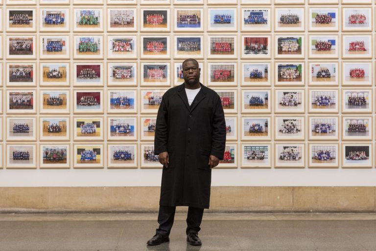 Steve McQueen e sullo sfondo il suo Year 3 alla Tate Britain © Tate. Photo Jessica McDermott