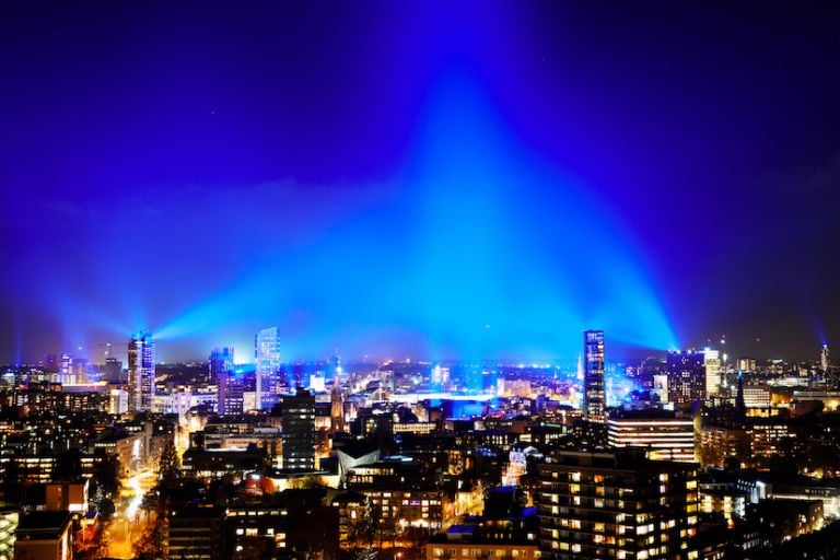 Nederland, Eindhoven, 12 november 2020. Met Connecting the Dots creëert het Eindhovense lichtfestival GLOW het grootste lichtkunstwerk ooit over 80 km2. De Finse lichtkunstenaar Kari Kola zorgt met 1500 lampen voor een blauwe mantel van licht over de stad. 1000 rode verlichte ballonnen door de Nederlandse kunstenaar Ivo Schoofs brengen verbinding aan. Eindhovens kunstenaar Hugo Vrijdag riep kinderen op een persoonlijke GLOWdot te maken, volwassenen deden ook mee. Er kunnen misschien wel 20.000 van deze klein lichtkunstwerkjes achter de ramen hangen. Vanwege de corona-pandemie is er dit jaar geen gebruikelijke GLOW looproute. Het lichtspektakel is overal in de stad en tot ver daarbuiten te zien. foto: GLOW / Bart van Overbeeke